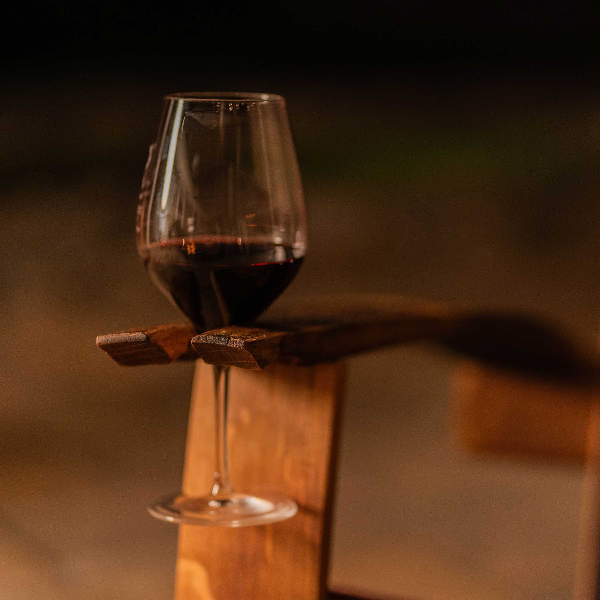 Close-up of Adirondack rocking chair with wine-stained oak and integrated glass holder in arm of chair.