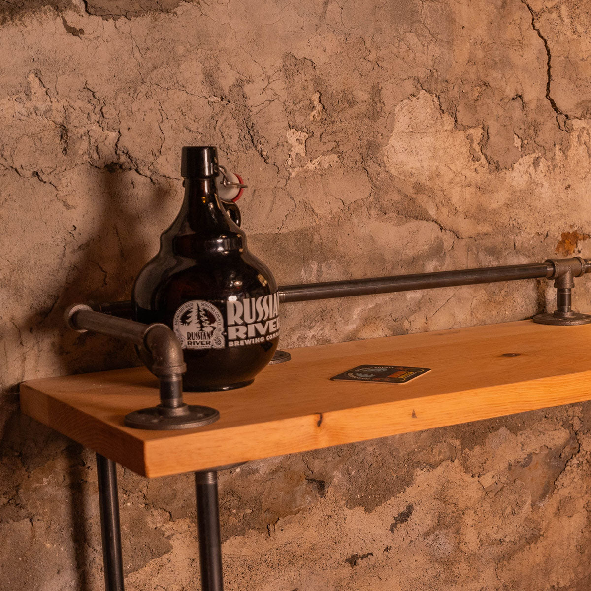 Wooden bar counter with a bottle and lamp against a stone wall