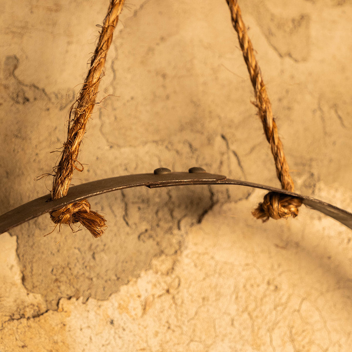 Detail of rope hanging hardware attached to the rustic reclaimed barrel-hoop wall shelf.