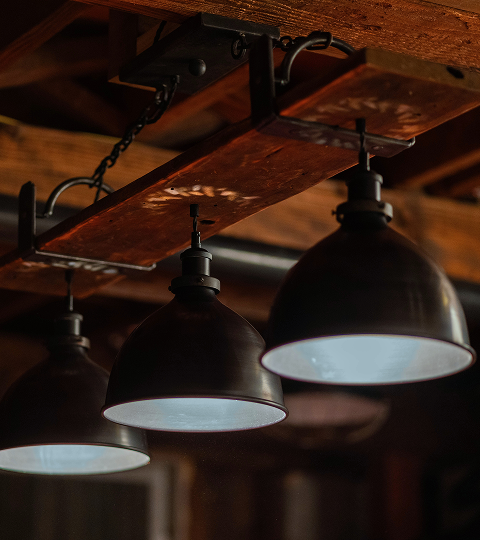 Rustic pendant lighting over a reclaimed wood pool table.
