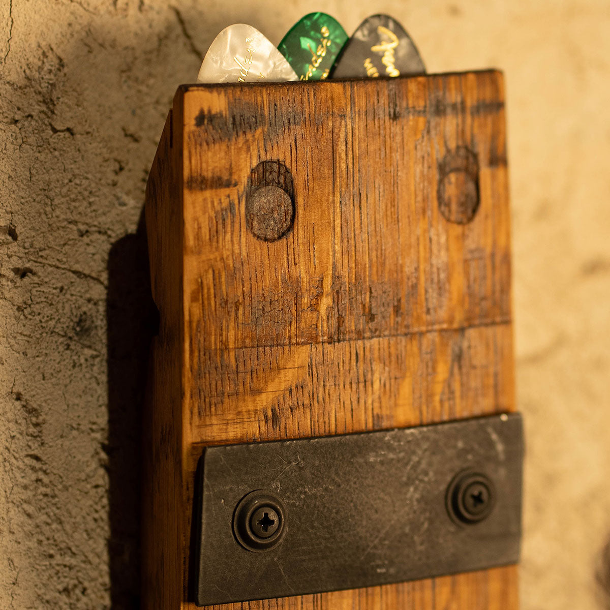 Close-up of a reclaimed wood guitar wall mount with pick storage at the top.