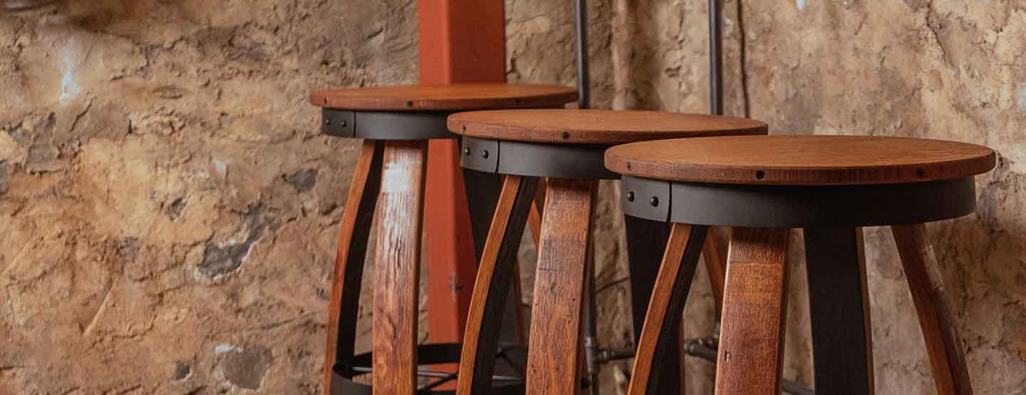 Rustic bar stools made from reclaimed barrel wood with steel accents.