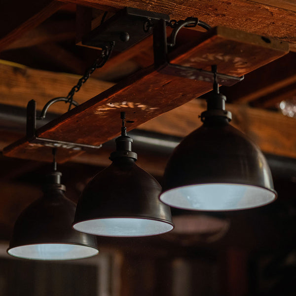 Three hanging lights with a rustic wooden ceiling