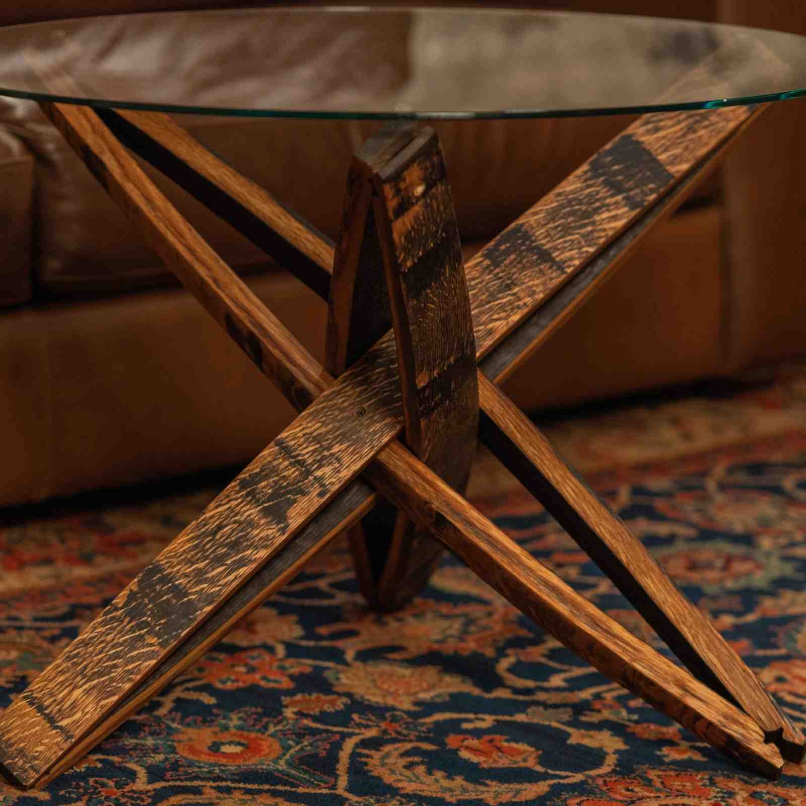 Close-up of the Stavv™ Whiskey Barrel Coffee Table base, showing the interlocking reclaimed barrel staves and rounded glass top.