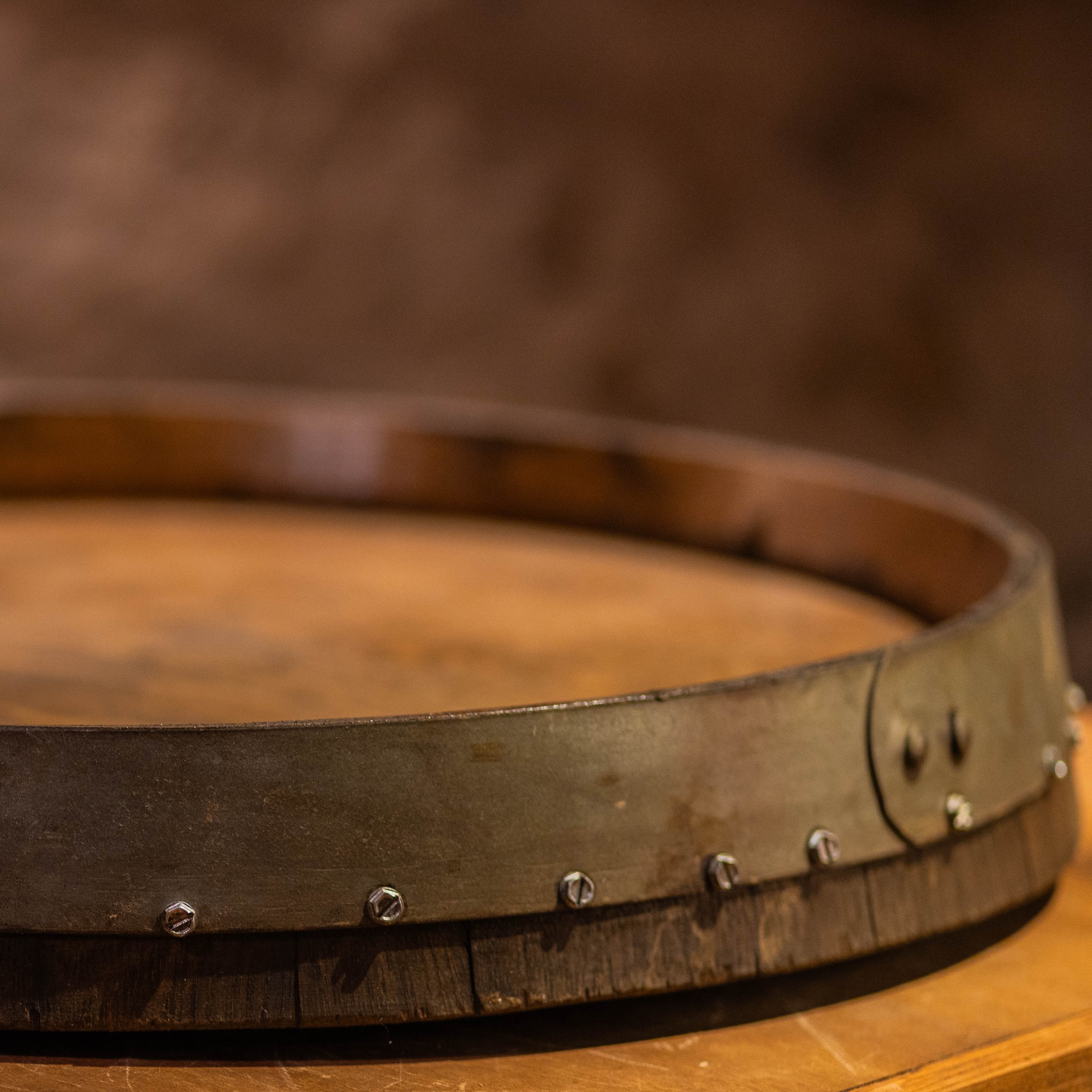Close-up of reclaimed barrel-head Lazy Susan showing raised metal hoop and wood surface.