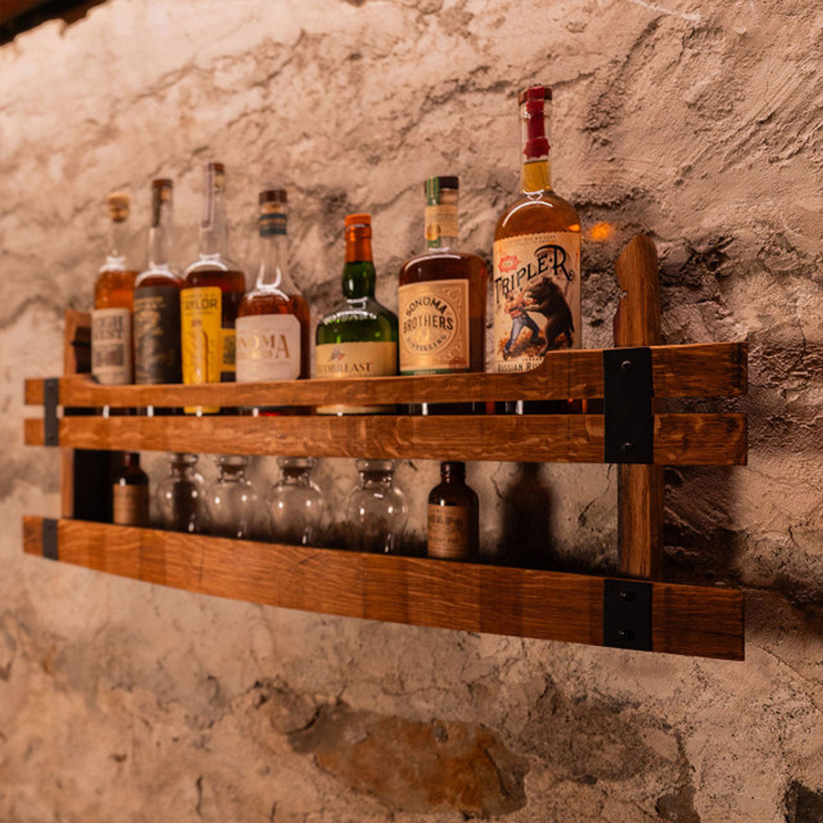 Wooden shelf with various bottles against a stone wall
